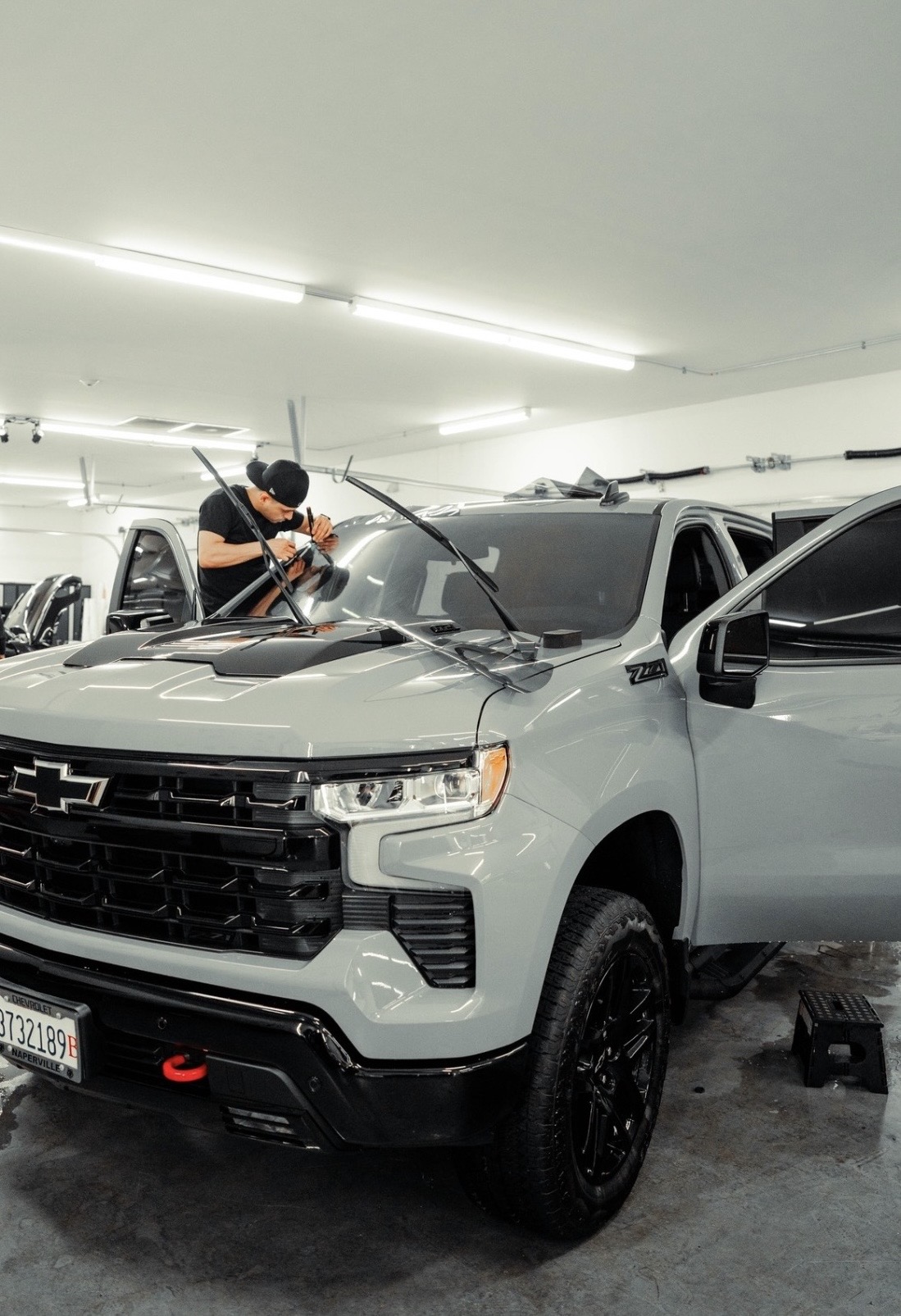 Tinted Chicago technician installing windshield tint on Chevy Silverado